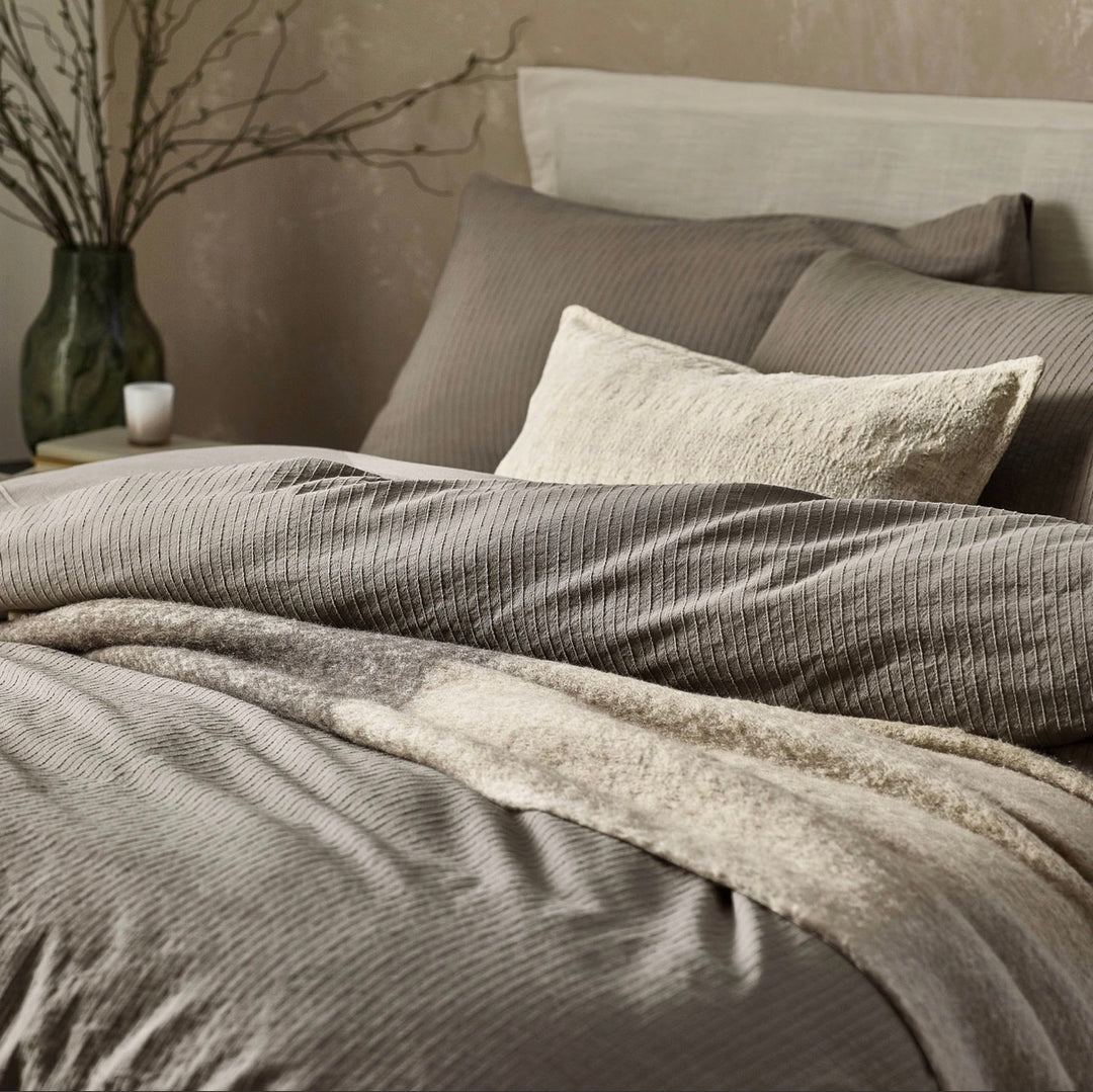 Ashby cushion styled on a bed